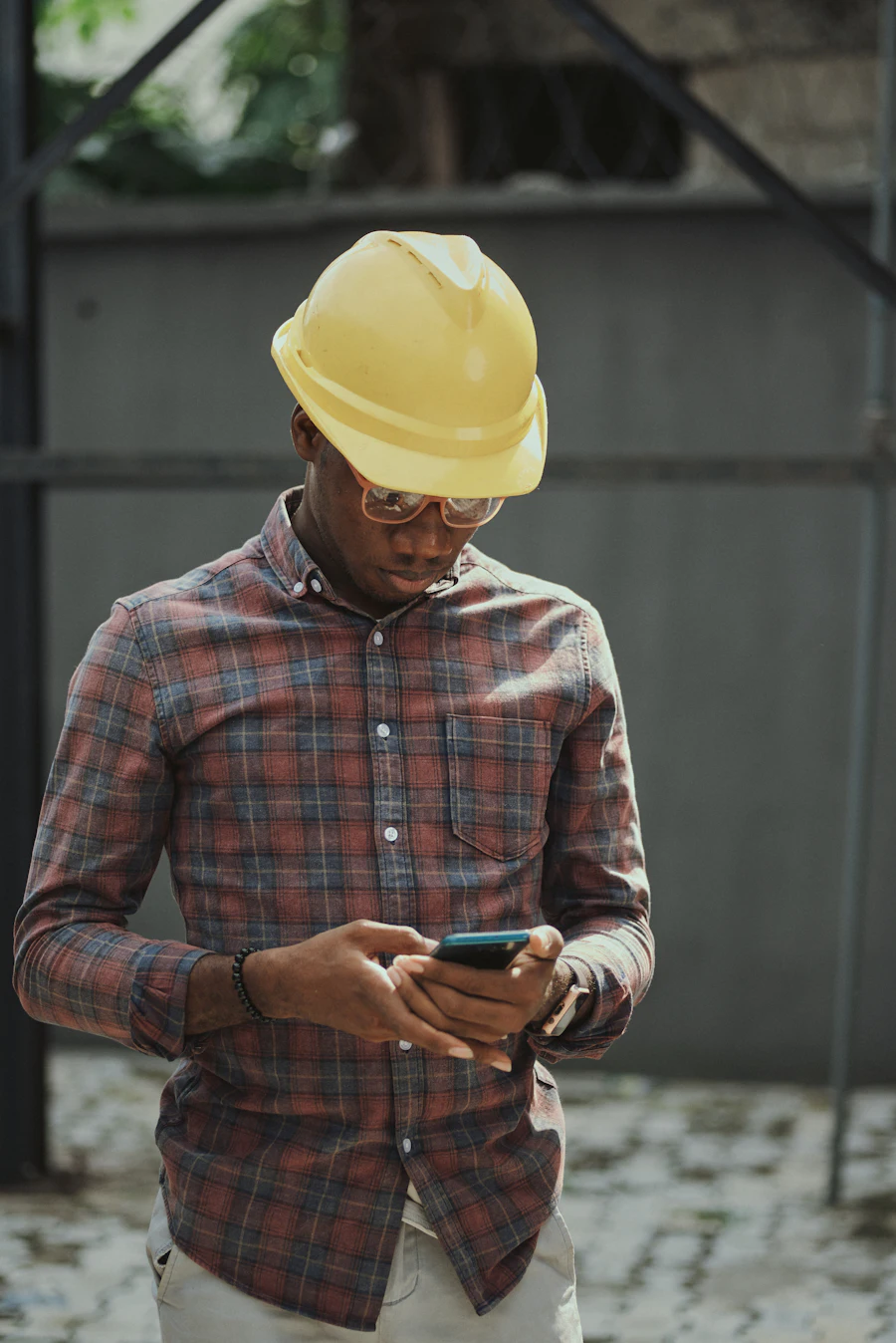 Site worker in a hard hat using a smartphone