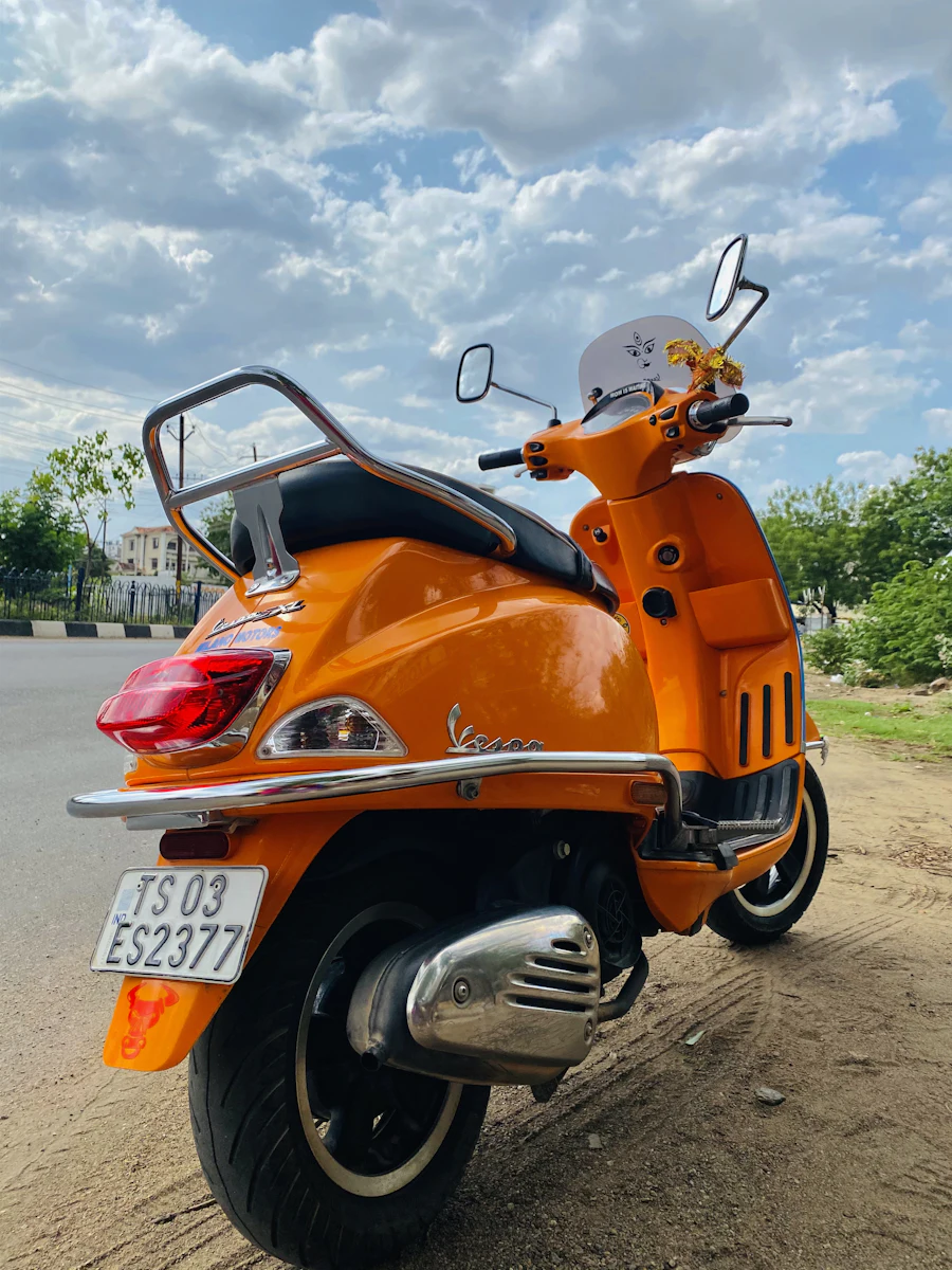 Orange scooter parked on a road