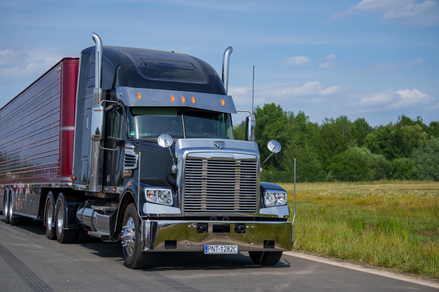 Black semi-truck on a rural road with AI damage detection boxes